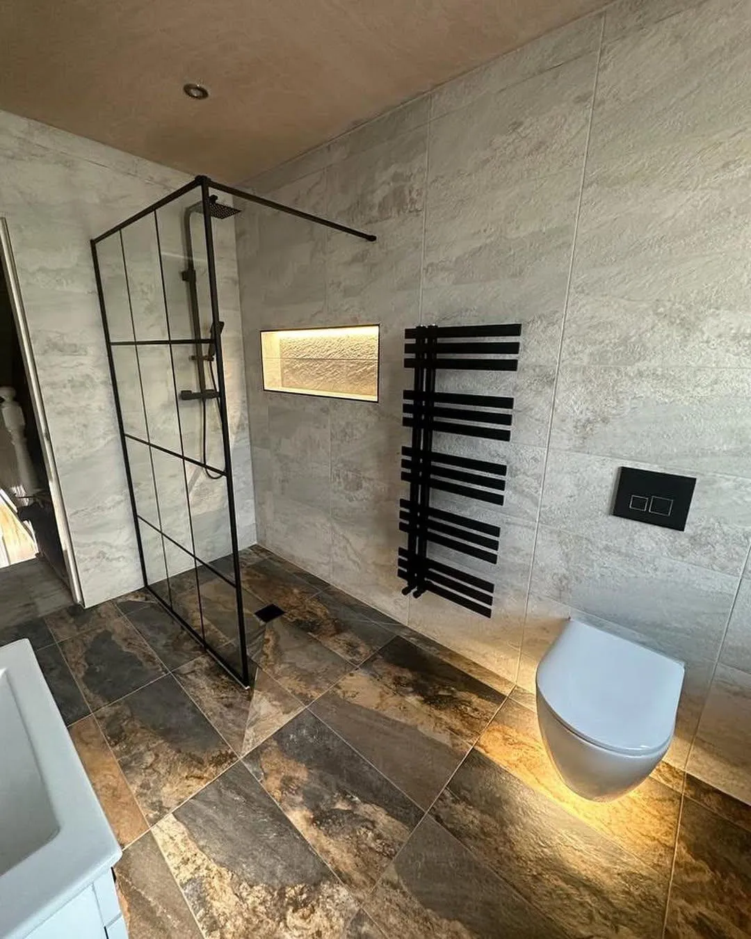 Contemporary wet room with floor-to-ceiling tiles and black fixtures